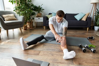 Genç adam rahat oturma odasında yoga yapıyor. Güç ve kararlılık gösteriyor..