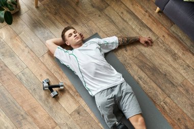 Young man rests after an intense workout session, showcasing resilience and determination. clipart