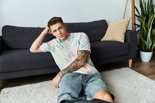 Красивый молодой человек с протезной ногой небрежно расположился в современном жилом пространстве.