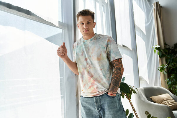 Молодой человек с большими окнами в светлой комнате источает индивидуальность и силу.