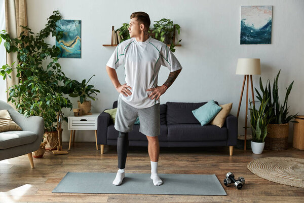 Handsome young man stands proudly in a modern living room, highlighting his prosthetic leg.