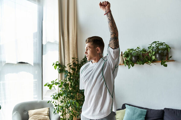 Молодой красивый мужчина уверенно растягивается в ярком жилом пространстве, наполненном растениями.