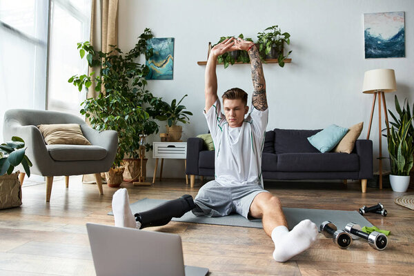 A handsome young man focuses on his stretching routine while sitting at home.