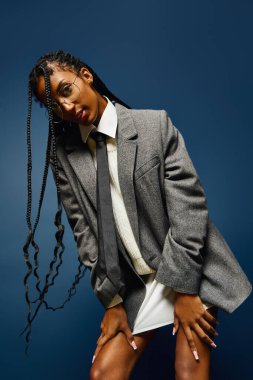 Canlı, mavi bir ortamda, şık genç bir kadın kendine güvenen eşsiz modasını sergiliyor..