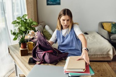 Genç bir kız evdeki şık odasında otururken okul malzemelerini düzenliyor..