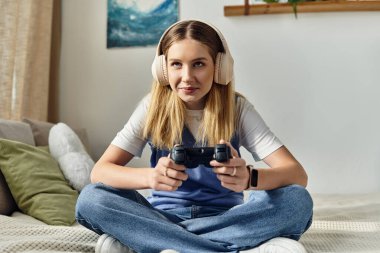 A teenage girl relaxes at home, immersed in video gaming, showcasing youth culture. clipart