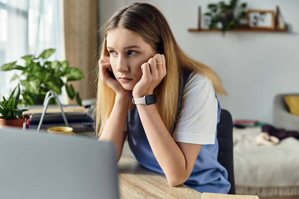 In a stylish room, a teenage girl thinks deeply while surrounded by her personal space.