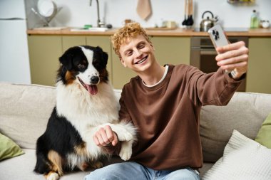 Neşeli kızıl saçlı bir adam, Avustralya çoban köpeğiyle açık yürekli bir selfie paylaşır..