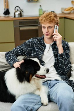 Modern bir dairede, genç bir kızıl saçlı kanepede rahatlar, telefonda köpeğiyle sohbet eder..
