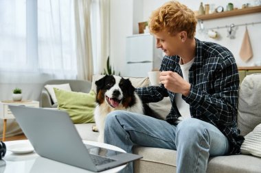 Modern bir dairede, genç bir kızıl kafa sevimli köpeğiyle oynaşmaktan zevk alır..