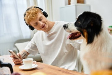 Modern bir dairede, bir adam Avustralyalı çobanıyla değerli anların tadını çıkarır..