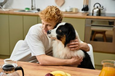 Genç bir kızıl saçlı Avustralyalı çobanıyla şık bir mutfakta sıcak bir kucaklaşmayı paylaşıyor..