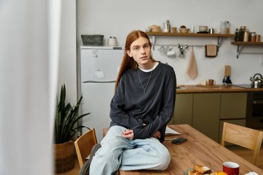 Şık dairesinde dinlenen, uzun saçlı genç bir adam rahat bir yaşam tarzını kucaklıyor..