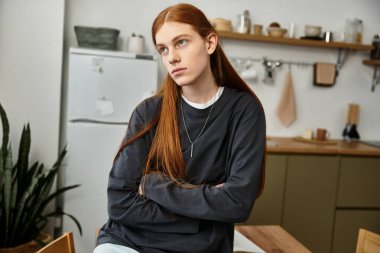 Sıradan bir genç adam şık dairesinde düşünceli bir şekilde oturuyor, rahat bir hava sergiliyor..