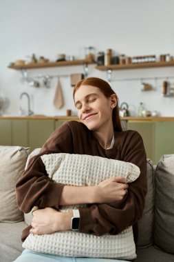 A young man with long red hair relaxes on a pillow in a stylish apartment. clipart