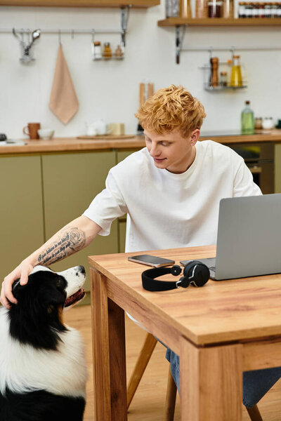 Молодой человек с яркими рыжими волосами взаимодействует со своей очаровательной австралийской овчаркой дома.