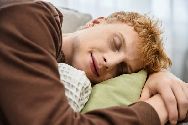 В современной квартире красивый рыжий мужчина мирно покоится на подушке..