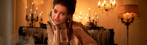 A young woman exudes an aura of magic, capturing the essence of a vampire amidst candlelight.