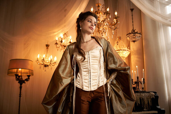 A young woman dressed in elegant Victorian style clothing stands gracefully in a mystical room.