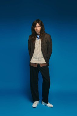 Şık bir genç adam kendine güvenerek modern moda eğilimleri sergiliyor..