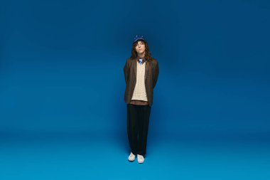 Şık giyimli genç bir adam kendine güvenerek kendine has tarzını sergiliyor..