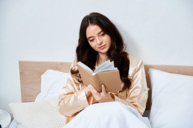 A young woman relaxes on her bed, reading a book and enjoying a peaceful morning. clipart