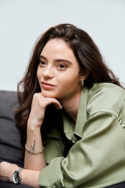 Uzun saçlı güzel bir kadın çenesini elinde tutuyor, evde dalgın dalgın dalgın dalgın dalgın dalgın dalgın yatıyor..