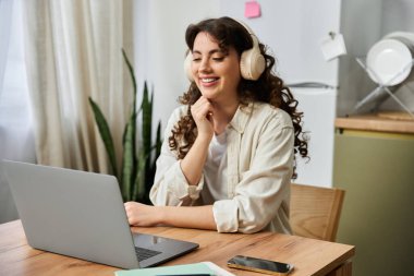 Güzel, genç bir kadın, rahat evinden gelen bir video konuşmasında gülümsüyor..