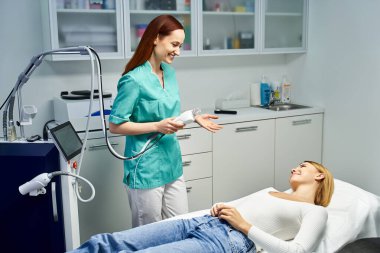 Profesyonel bir dermatolog, gösterişli bir klinikte genç bir hastaya cilt bakımı uygular..