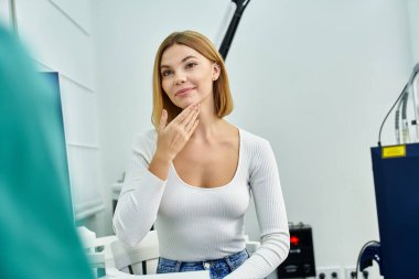 Genç bir kadın, şık bir klinikte cilt bakımı konusunda bir cildiyeciye danışmanlık yapıyor..