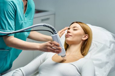 Yetenekli bir pratisyen, rahat genç bir kadın üzerinde dermatoloji prosedürü uygular..