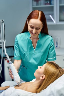 Genç bir kadın, iyi aydınlatılmış bir dermatoloji kliniğinde, dost bir destekçiyle cilt tedavisi görüyor..