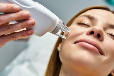 Genç bir kadın, klinikte doğal güzelliğini arttıran bir dermatoloji prosedüründen hoşlanır..