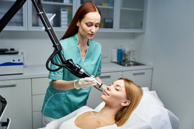 Yetenekli bir profesyonel, genç bir kadının cilt bakımında modern dermatoloji teknikleri kullanır..