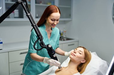 Bir dermatolog, klinik ortamında genç bir kadını tedavi ediyor..