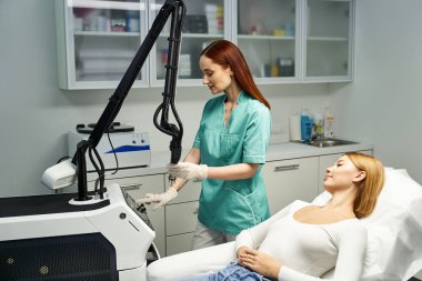 Yetenekli bir dermatolog genç bir hastayı parlak bir klinikte tedavi ediyor..