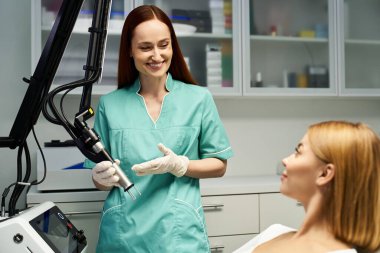 Yetenekli bir dermatolog, parlak bir klinikteki genç bir kadına prosedürü açıklıyor..