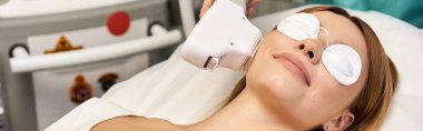 Genç ve güzel bir hasta, bir klinikte özel ekipmanlarla dermatoloji işleminden zevk alır..
