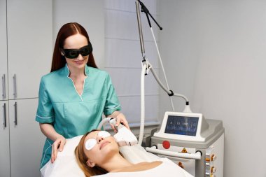 Yetenekli bir profesyonel modern bir klinikte genç bir kadına cilt bakımı yapıyor.