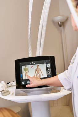 Genç bir dermatolog, ileri cilt işlem teknolojisi kullanan bir hastayı tedavi ediyor..