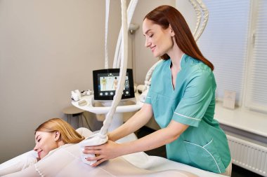 Genç bir kadın şık bir klinikte dermatoloğundan cilt ameliyatı oluyor..