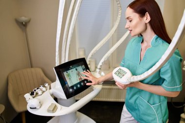 Yetenekli bir dermatolog, bir klinikte cilt bakımı için gelişmiş aletler kullanır..