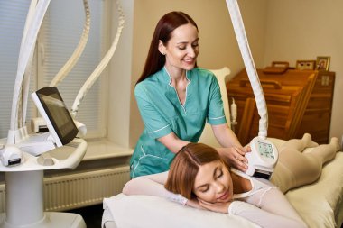 Yetenekli bir dermatolog sakin bir klinikte rahat genç bir kadını tedavi ediyor..