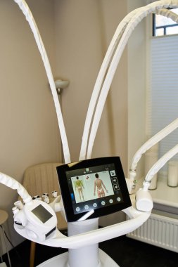 Deri işlemleri için gelişmiş makineler kullanıma hazır, sakin bir dermatoloji kliniğinde bekliyor..