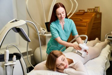 Yetenekli bir teknisyen, sakin bir klinikte rahat bir genç kadın üzerinde dermatoloji prosedürü uyguluyor..