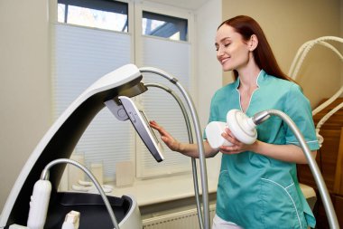 Yetenekli bir dermatolog, müşterilerine cilt tedavisi sağlarken gelişmiş ekipman kullanır..