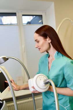 Young and beautiful dermatologist skillfully operates equipment during a skin treatment session. clipart