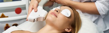 A young woman relaxes with eye protection during a dermatology treatment for her skin. clipart