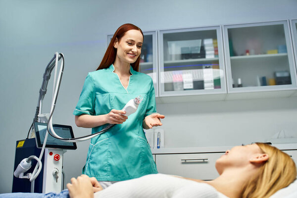 A beautiful young woman relaxes while receiving a dermatological treatment from a specialist.