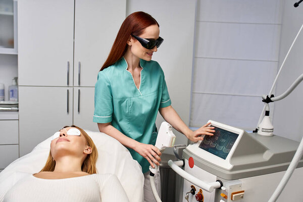 A young woman receives a skin treatment from a professional in a modern dermatology clinic.